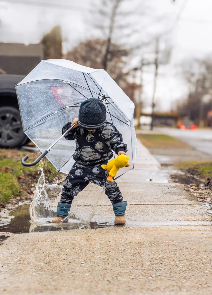 Copil cu umbrelă într-o zi ploioasă, simbol pentru planul de rezervă